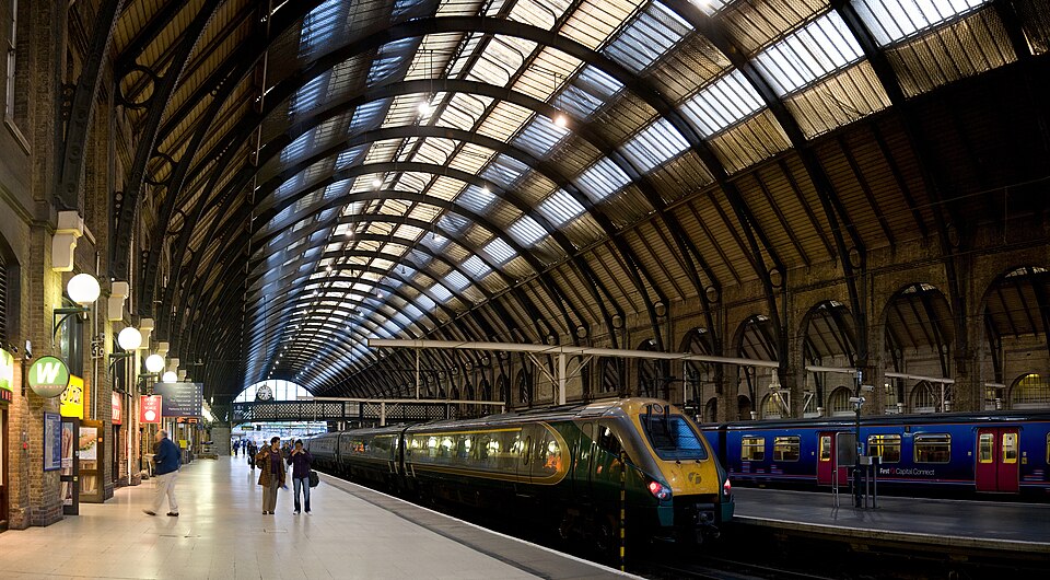 Trains waiting at the platforms under the arched roof of London King's Cross station